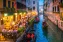 Romantic sundown atmosphere in a channel in Venice with boats and restaurants