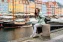 Young Woman smiling and sitting at the Old Port in Copenhagen, Demnark