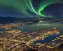 a view of of the city of bergen from the top at night with the polar lights visible